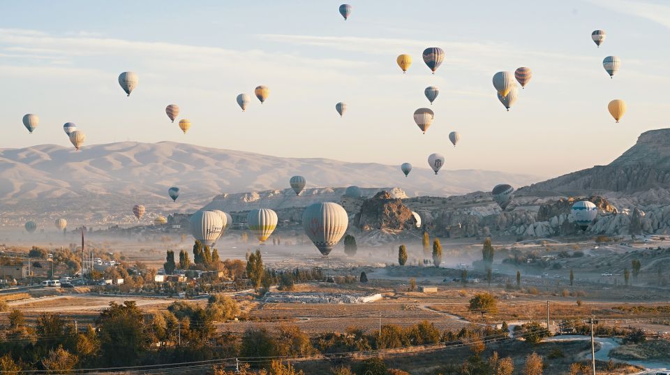 Hot air balloons in Goreme red valley - Uchisar Castle: a viewpoint built into the rock